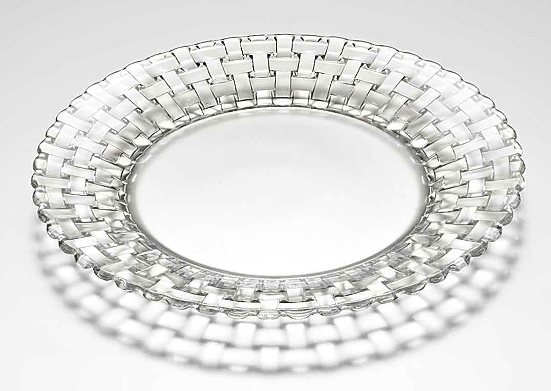 Clear glass plate with woven design on a light gray background
